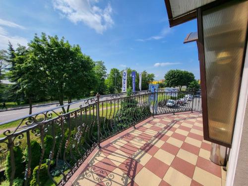 a balcony with a wrought iron fence and a sidewalk at Hotel Hesperus in Międzyrzec Podlaski