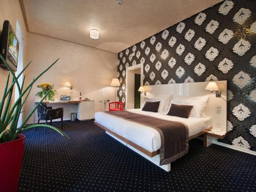 una camera d'albergo con un grande letto e una scrivania di EA Hotel Tereziánský dvůr a Hradec Králové