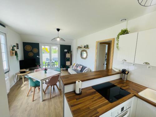 une cuisine et un salon avec une table et un canapé dans l'établissement Durion, Maison proche plage avec jardin, à Bernières-sur-Mer