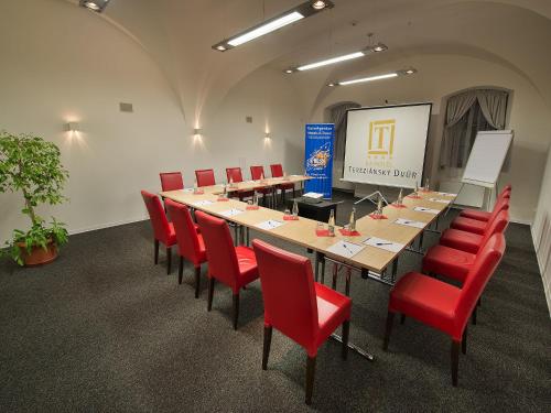 a conference room with a long table and red chairs at EA Hotel Tereziánský dvůr in Hradec Králové