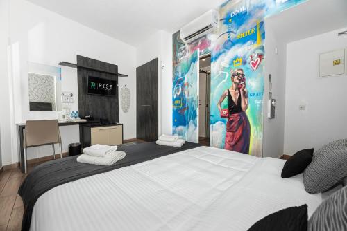 a bedroom with a large bed with a painting on the wall at Rise Urban Art Hotel in Larnaka