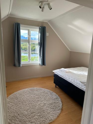 a bedroom with a bed and a window at Nordlandshus Lofoten in Berg