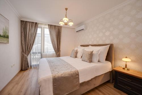 een slaapkamer met een groot bed en een raam bij Prestige Central Apartments in Varna