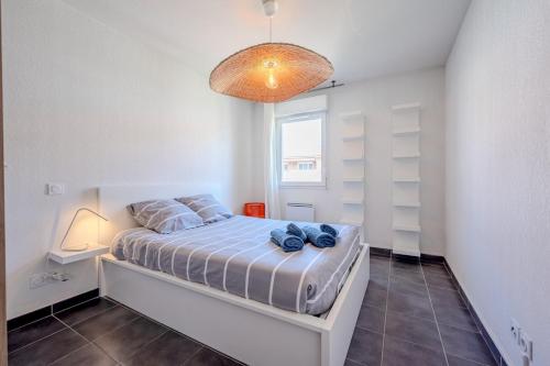 - une chambre dotée d'un lit avec des chaussures bleues dans l'établissement Le Neroli T2 dernier étage avec Terrasse et garage, à Toulon