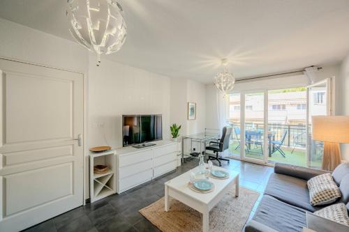un salon avec un canapé, une télévision et une table dans l'établissement Le Neroli T2 dernier étage avec Terrasse et garage, à Toulon
