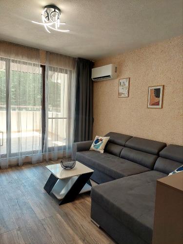 a living room with a couch and a table at Art Sense Мезонет in Shkorpilovtsi