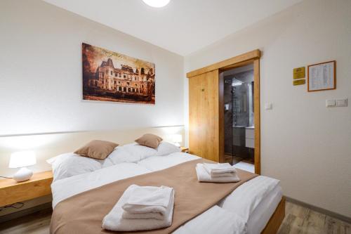 a bedroom with two beds with towels on them at Hotel Kaskada in Poprad