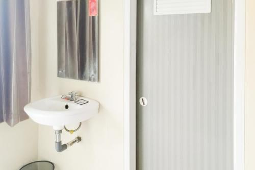 une salle de bain avec un lavabo et un miroir dans l'établissement RedDoorz Syariah at Shakira Alesha Enggal, à Bandar Lampung