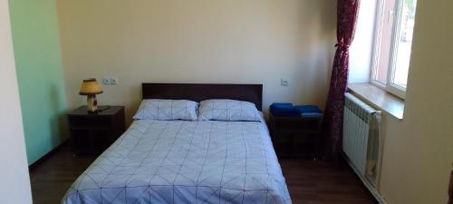 a bedroom with a bed with a blue comforter at Sevan Backstage Garden in Sevan