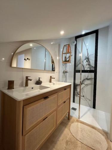 une salle de bain avec un lavabo et un miroir dans l'établissement La maison rose du centre-ville !, à Muzillac