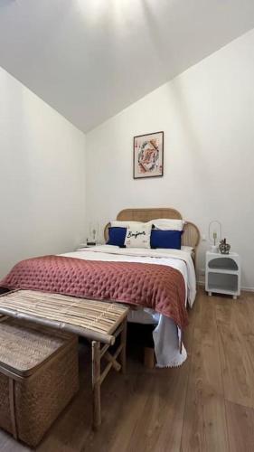 - une chambre avec un lit doté d'une couverture rouge et d'oreillers bleus dans l'établissement La maison rose du centre-ville !, à Muzillac