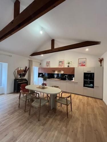 une pièce avec une table et des chaises et une cuisine dans l'établissement La maison rose du centre-ville !, à Muzillac