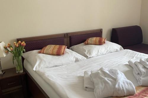 two beds with white sheets and pillows in a bedroom at Kolštejn wellness centrum in Branná