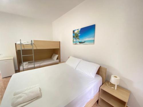 a small bedroom with a bed and a bunk bed at Yard Paradise in Dhërmi