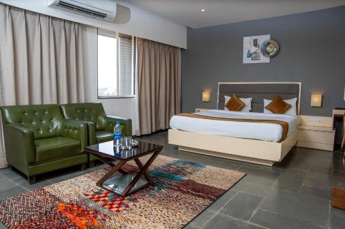 达尔瓦德Hotel Dwarawata的一间卧室，里面有一张床、一张沙发和一张桌子