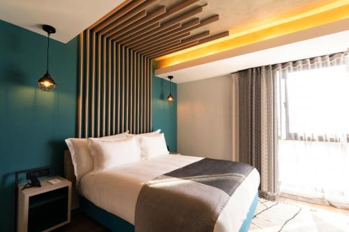 a bedroom with a large bed and a window at Kaan Casablanca in Casablanca