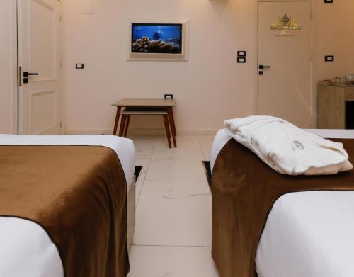 two beds in a room with a table at Horizon Pyramids View inn in Cairo