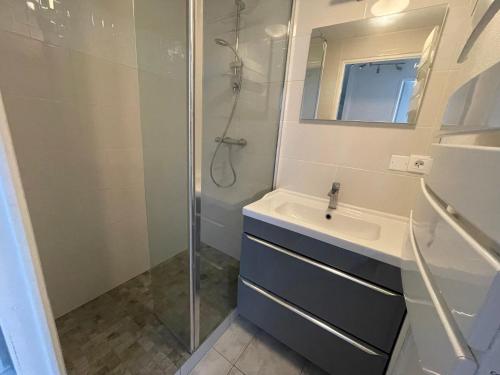 une salle de bain avec un lavabo et une douche dans l'établissement Maisonette proche plage, à Colleville-Montgomery