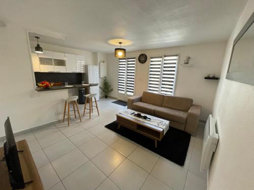 un salon avec un canapé et une table dans l'établissement Maisonette proche plage, à Colleville-Montgomery