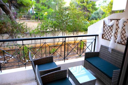 a balcony with two chairs and a table and a railing at Chic & Calm apartment 3 minutes walk to Rafina Beach in Rafina