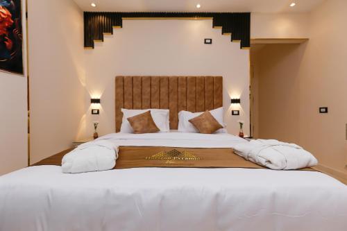 a bedroom with a large bed with white sheets and pillows at Horizon Pyramids View inn in Cairo