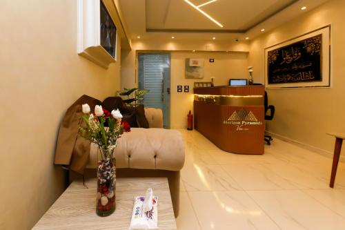 a waiting room with a couch and a vase of flowers at Horizon Pyramids View inn in Cairo
