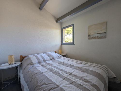 una camera da letto con un letto e una finestra di Maison de vacances avec jardin, 650m de la mer, WIFI,CLIM a Saint-Cyprien