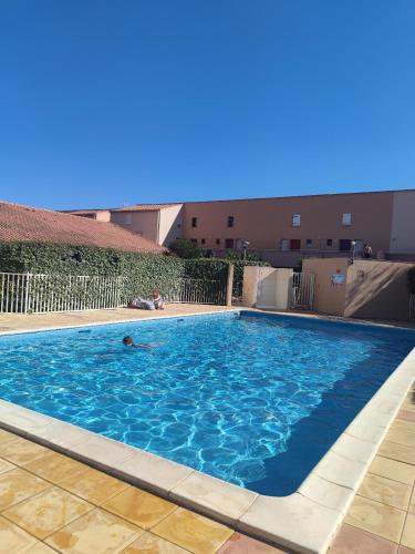 une personne nageant dans une grande piscine dans l'établissement Les pieds dans l'eau aux Mers du Sud - Gruissan Les Ayguades, à Gruissan