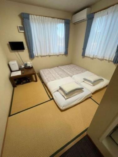 a bedroom with a large bed and a table at Karin doo Hotel in Narita