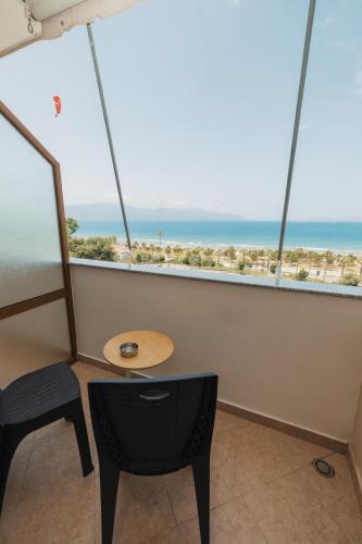 a table and chair in a room with a view of the beach at Voyage Villa in Vlorë