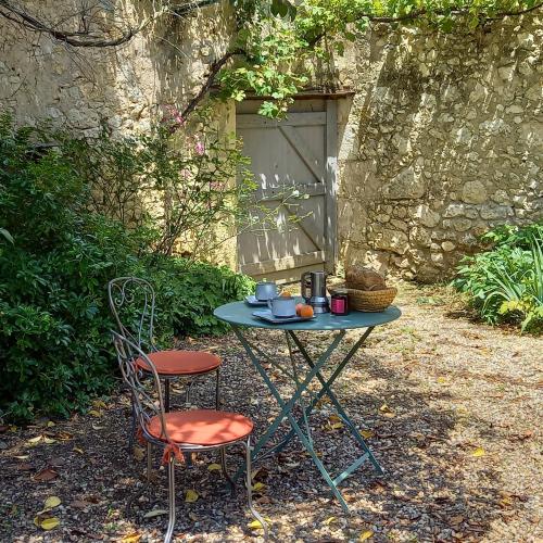 einen Tisch und zwei Stühle vor einem Gebäude in der Unterkunft Entre-vignes-et-bastides in Montcaret
