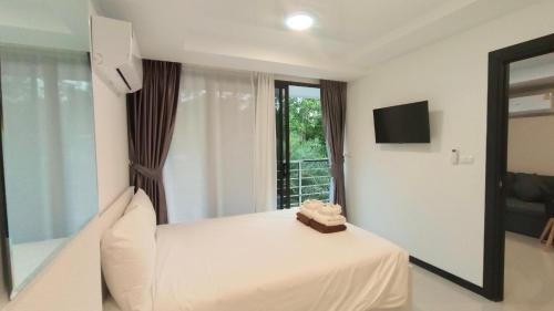 a hotel room with a bed and a window at Rawai Beach Condo by Holy Cow in Nai Harn Beach