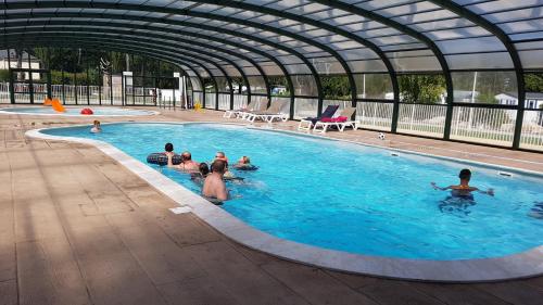 un groupe de personnes dans une piscine dans l'établissement Camping Saint Laurent, à Ploemel