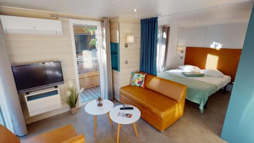 a hotel room with a bed and a couch at Au Paradis des Campeurs in Les Issambres