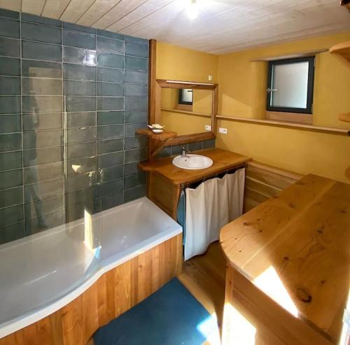 ein Badezimmer mit Badewanne und Waschbecken in der Unterkunft La Maison du hêtre in Brassac