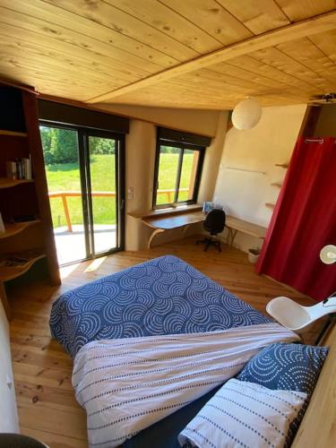 ein Schlafzimmer mit einem großen Bett in einem Haus in der Unterkunft La Maison du hêtre in Brassac