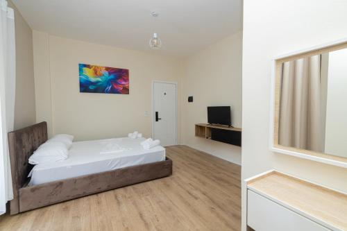 a white bedroom with a bed and a window at Voyage Villa in Vlorë