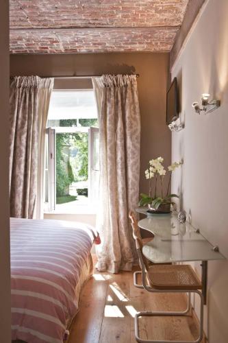 a bedroom with a bed and a table and a window at Lozerkasteel in Kruishoutem