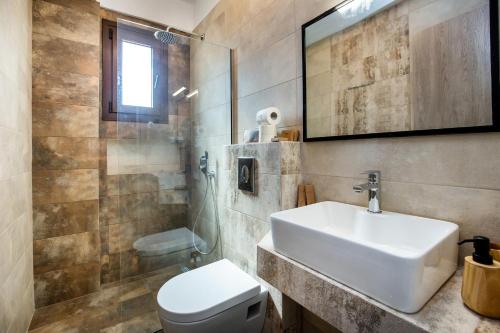 a bathroom with a sink and a toilet and a shower at House Rytha in Limenaria