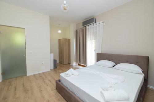 a bedroom with a large bed with white sheets and pillows at Voyage Villa in Vlorë