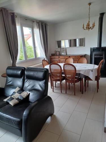 un salon avec un canapé en cuir noir et une table dans l'établissement Maison cosy 600m de la gare de Rambouillet, à Rambouillet
