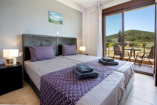 a bedroom with a bed with two towels on it at House Rytha in Limenaria