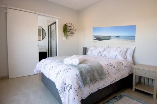 a bedroom with a bed and a picture of the ocean at Shelley Point Estate Blue Avion Luxury Holiday Home Solar Powered in St Helena Bay