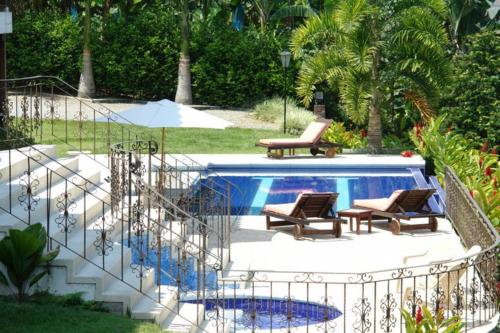 a swimming pool with two chairs and a staircase next to it at Hotel Campestre la Navarra in La Suiza