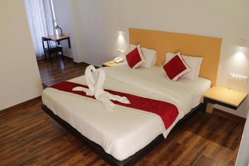 a hotel room with a bed with a white animal on it at Parivar Comfort Luxury Rooms in Virār