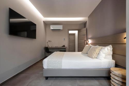 a bedroom with a large white bed and a desk at The Point Suites Rome - Guest House in Rome