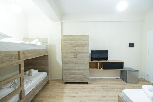 a bedroom with two bunk beds and a television at Voyage Villa in Vlorë