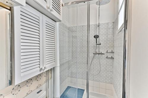une salle de bain avec une douche avec une porte vitrée dans l'établissement Appartement parisien spacieux #Marais #Rivoli, à Paris