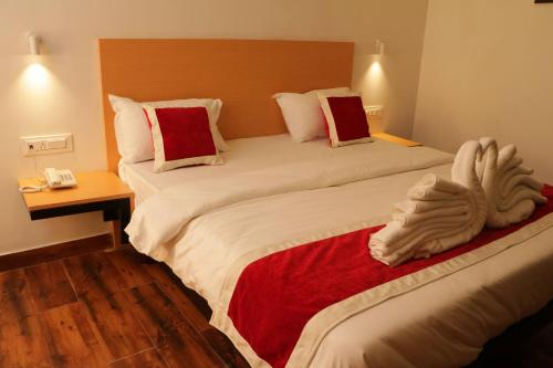 two beds in a hotel room with a stuffed animal on the bed at Parivar Comfort Luxury Rooms in Virār