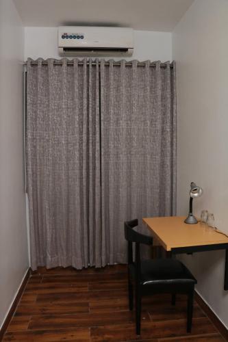 a room with a table and a curtain at Parivar Comfort Luxury Rooms in Virār